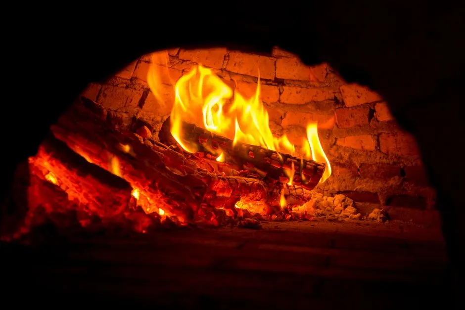 Close-up of a vibrant fire burning in a brick fireplace, exuding warmth and coziness.